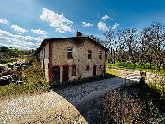 Historisches Gebäude Alter Pferdestall auf dem Hermannshof in Rheinsberg mit Backsteinelementen und Kopfsteinpflaster